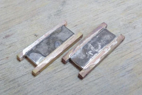 welding of the white gold plates onto the links of the yellow gold bracelet