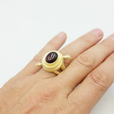 snake signet ring worn on hand with red garnet stone