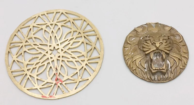 two of the three parts used to assemble the men's lion pendant