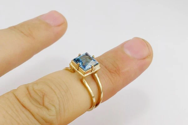 gold engagement ring with blue topaz stone